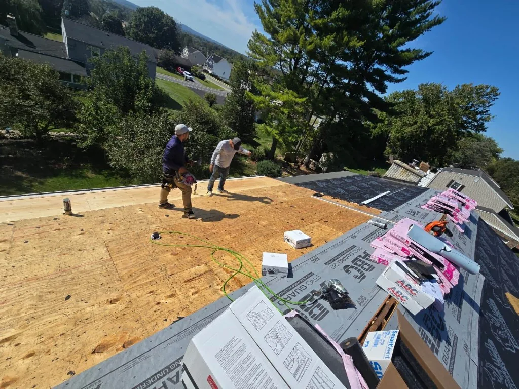 Roofing crew installing underlayment after storm damage on an emergency roof repair in Doylestown, PA